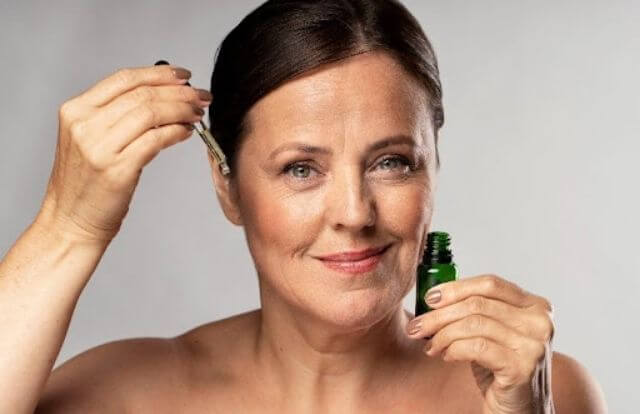 mulher aplicando produto no rosto para retardar o aparecimento de rugas na pele
